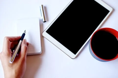 Office, tablet and hand with notepad, coffee and writing ideas on table, cr.. Foto stock