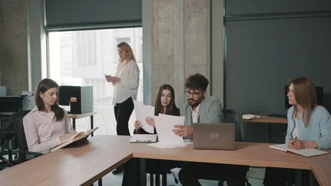 Office team collaborates on documents showcasing teamwork Stock-Footage 312259764