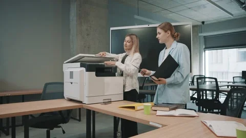 Office team collaborates at workplace around copier during busy work hours Stock Footage 326324055