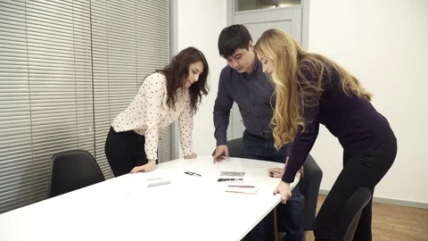 Office team is gathered around the table discussing the ideas Stock Footage 73992557