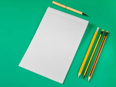Office theme.Open notebook,pencils and pen on a green background Foto stock