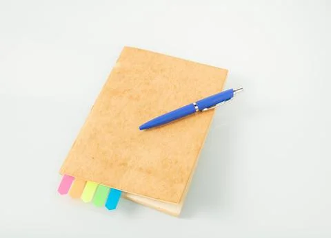 Office tools. Notebook with colored bookmarks and a blue fountain pen on a light Stock Photos