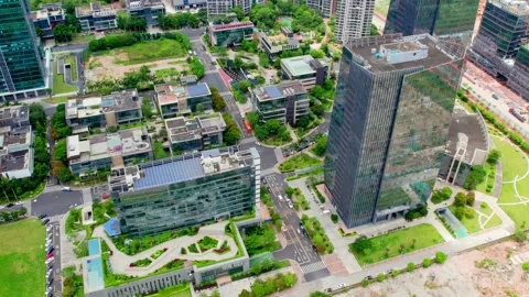 Office tower beside low rise roofs and gardens in Guangzhou China Stock Footage 345958284