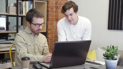 In the office, two young men work in front of the computer. Stock Footage 77608018