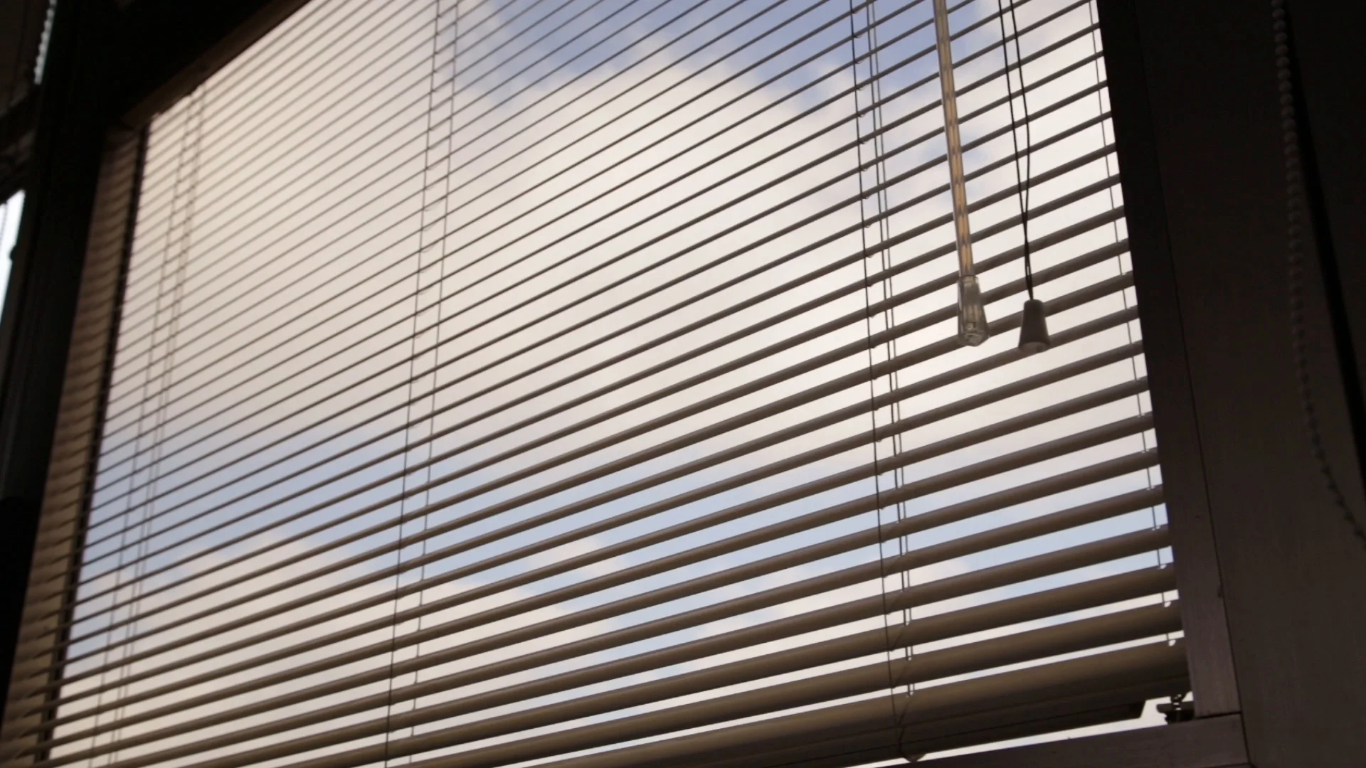 Office window with half closed venetian blinds