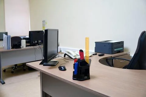 An office without people with desks with computers and a printer Stock Photos