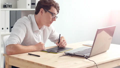 Office work concept. Graphic designer sitting at desk with laptop and tablet Stock Footage 92576352
