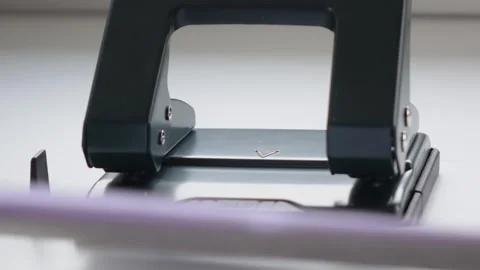 Office work, a man uses a hole punch to make holes in the paper. Video stock 144653431