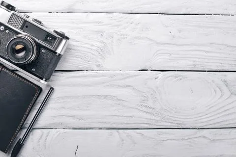 Office work space with camera, notebook, eyepieces, and pen. On a wooden surf Stock Photos