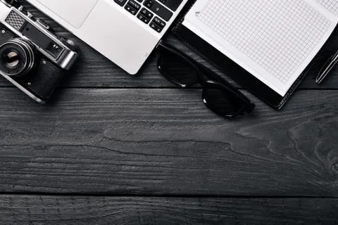 Office work space with camera, notebook, eyepieces, and pen. On a wooden surf Stock Photos