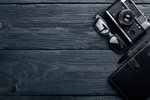 Office work space with camera, notebook, eyepieces, and pen. On a wooden surf Stock Photos