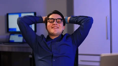 Office worker after a hard day of work relaxes with his hands behind his head Stock Footage 262082263