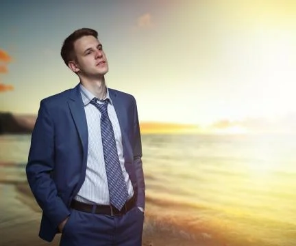 Office worker on the beach during sunset. Stock Photos