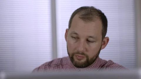 An office worker with beard taking notes on a skype call Stock Footage 73124380