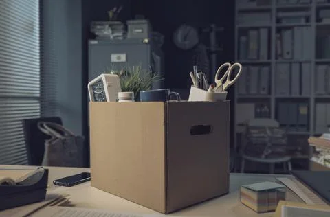 Office worker belongings in a cardboard box Stock Photos