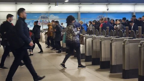 Office worker commuters at rush hour pass ticket machines barriers at London's Stock Footage 102586326