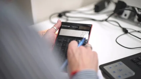 Office worker counts on calculator, works with documents. Company statistics. Stock Footage 126694597