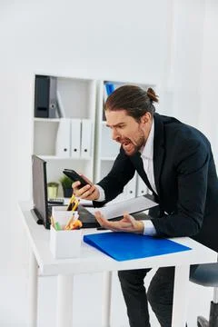 Office worker at the desk documents communication by phone technology Stock Photos