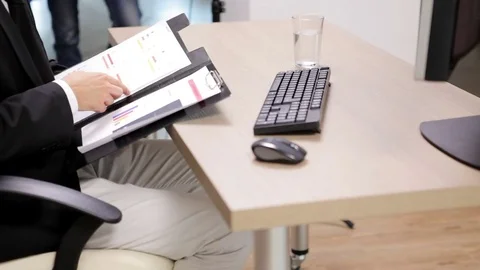 Office worker at desk with a keyboard next to folder with planes Stock Footage 83758470