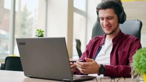 Office worker distracted from work using smartphone to check social network Stock Footage 220726346