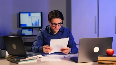 Office worker does not have time to do all the tasks. Man sits at two laptops 動画素材 262370994