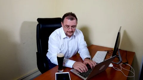 Office worker drinks beer after finishing work Stock Footage 115232957