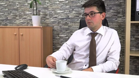 Office worker drinks coffee talking with a client at the workplace. Stock Footage 115790027