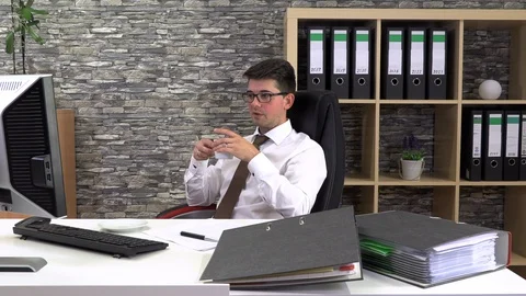 Office worker drinks coffee talking with a client at the workplace. Stock Footage 115833712