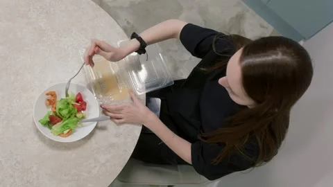 Office worker eating salad from plastic container at lunch break Stock Footage 308785580