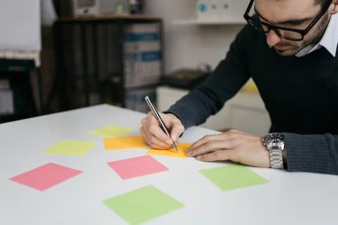 Office worker with eyeglasses writing notes using pen Stock Photos