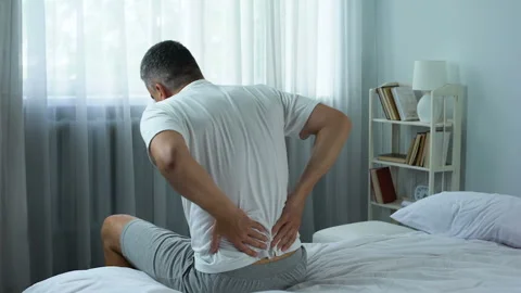 Office worker feeling sharp pain in back getting out of bed, sedentary lifestyle Stock-Footage 91564441