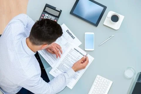 Office worker filling out contract documents. Stock Photos