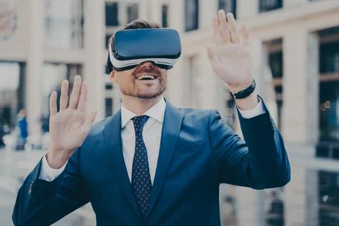 Office worker in formal suit exploring virtual world with VR glasses while Foto stock