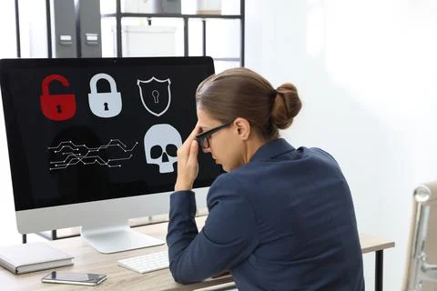 Office worker in front of computer with warning about virus attack on screen Foto stock