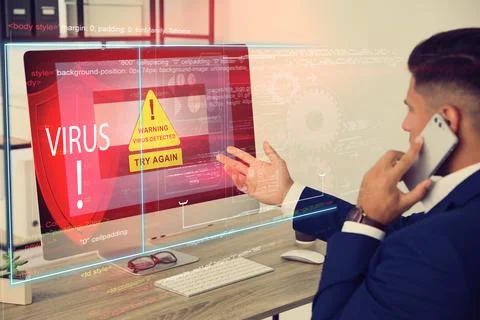 Office worker in front of computer with warning about virus attack on screen Stock Photos