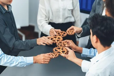 Office worker holding cog wheel as unity and teamwork in workplace. Concord Stock Photos