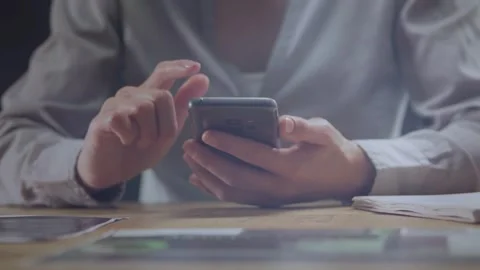 Office worker holding smartphone, right hand initiating taps and swipes, Stock Footage 334694125