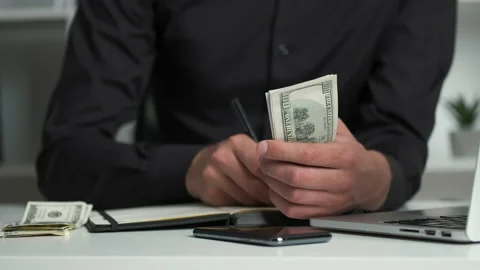 An office worker with a keen eye counts the money and writes it in a notebook 스톡 동영상 133636794