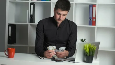 An office worker with a keen eye counts the money and writes it in a notebook Stock Footage 133642967