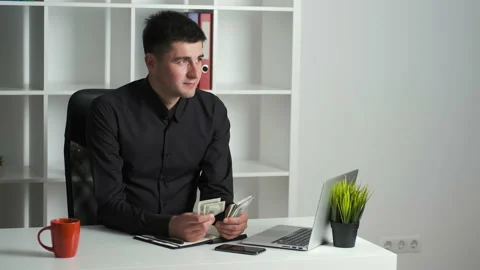 An office worker with a keen eye counts the money and writes it in a notebook Stock Footage 134163084