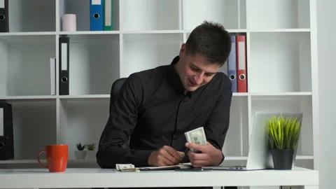 An office worker with a keen eye counts the money and writes it in a notebook Stock Footage 138584179