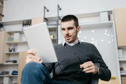 Office worker looking into a tablet and holding eyeglasses Stock Photos