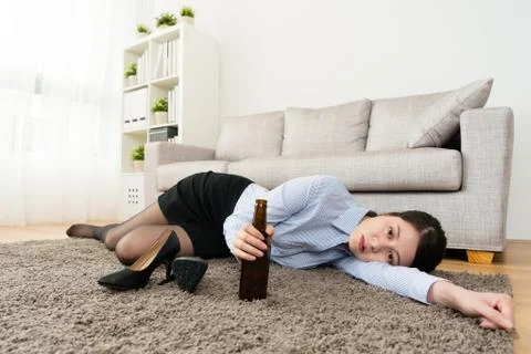 Office worker lying down on living room floor Stockfoto's