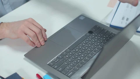 Office worker opens a laptop and types. Close up Stock Footage 129983920