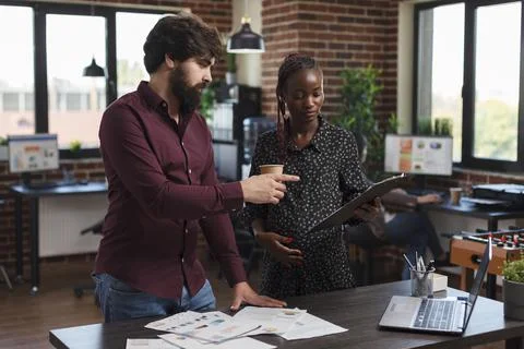 Office worker pointing out wrong accounting data while expectant mother having a Stock Photos