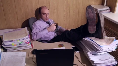 Office worker puts his feet on the table Stock Footage 72693257