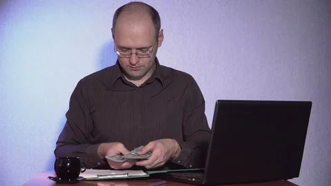 Office worker puts money in folder on table and looks at laptop Stock Footage 92838960