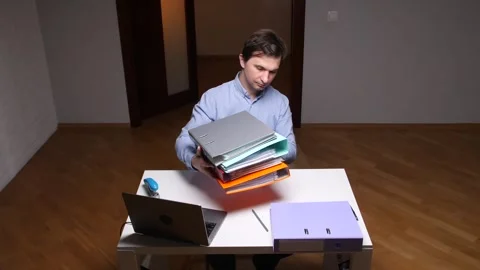 Office worker putting binders on desk at night Stock Footage 307038998