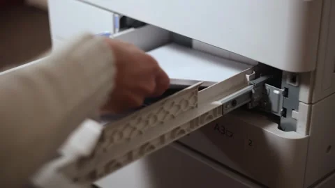 Office worker putting a stack of paper into the printer tray Stock Footage 294628209
