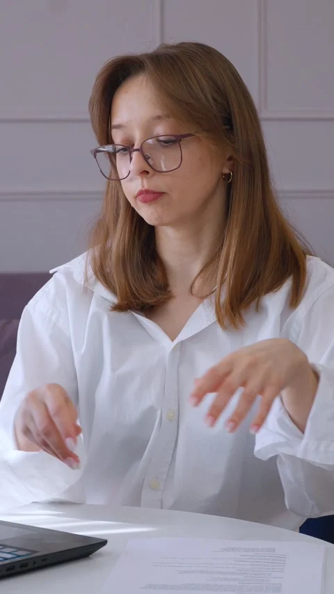 Office worker reading documents and typing on laptop Video stock 314622435